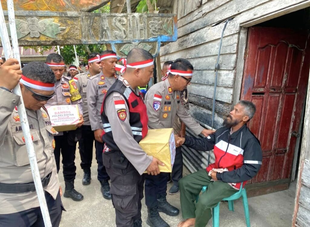 Polsek Bintan Utara Bagikan Bendera dan Sembako kepada Warga Pesisir Busung